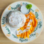 Traditionelles thailändisches Mango Sticky Rice mit frischen Mangos und Kokosnusssoße.