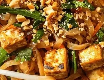Veganes Tofu Pad Thai mit frischem Gemüse und Erdnüssen in einer würzigen Sauce