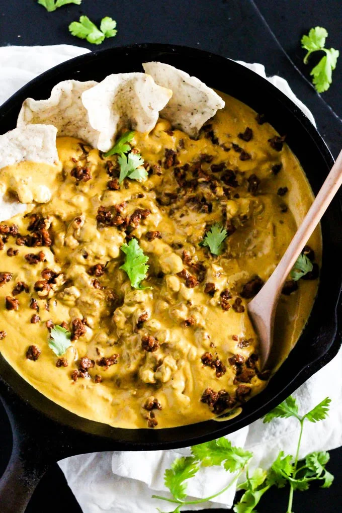 Veganes Cashew Queso Chili Dip in einer Schüssel mit frischen Zutaten