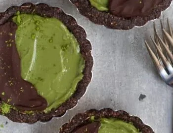 Veganer Matcha Tart in einer modernen Präsentation, dekoriert mit frischen Zutaten.