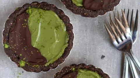Veganer Matcha Tart in einer modernen Präsentation, dekoriert mit frischen Zutaten.