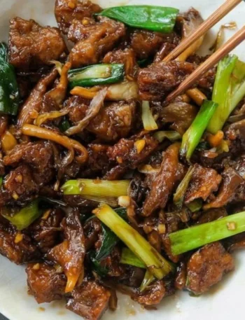 Vegan Mongolian Rindfleisch mit Pilzen auf einem Teller serviert.