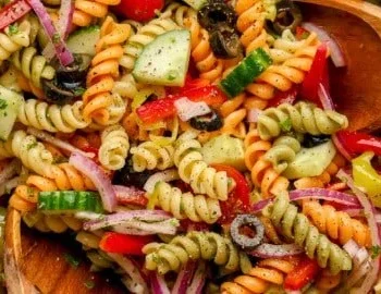 Ein Teller mit veganem Pasta-Salat, bunte Zutaten, frisch und gesund.