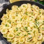 Vegane cremige Zitronenpasta mit Erbsen in einer Schüssel serviert.