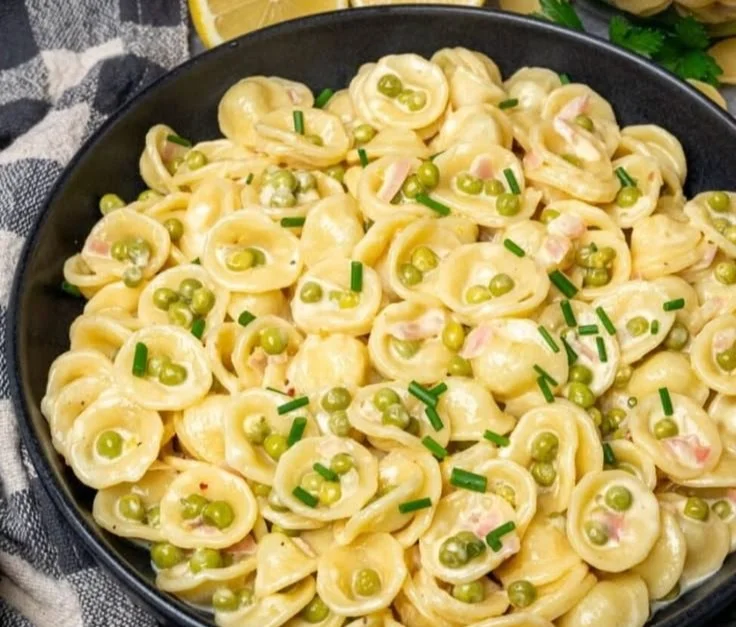 Vegane cremige Zitronenpasta mit Erbsen in einer Schüssel serviert.