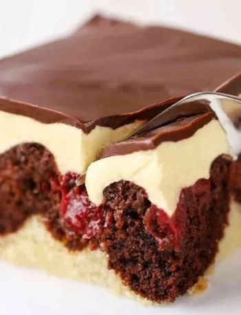 Vegane Donauwelle auf einem Teller mit frischen Beeren und Schokoladenglasur