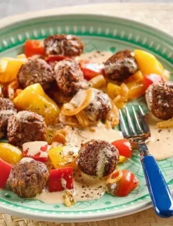 Vegane Frikadellen in cremiger Paprikasauce serviert auf einem Teller