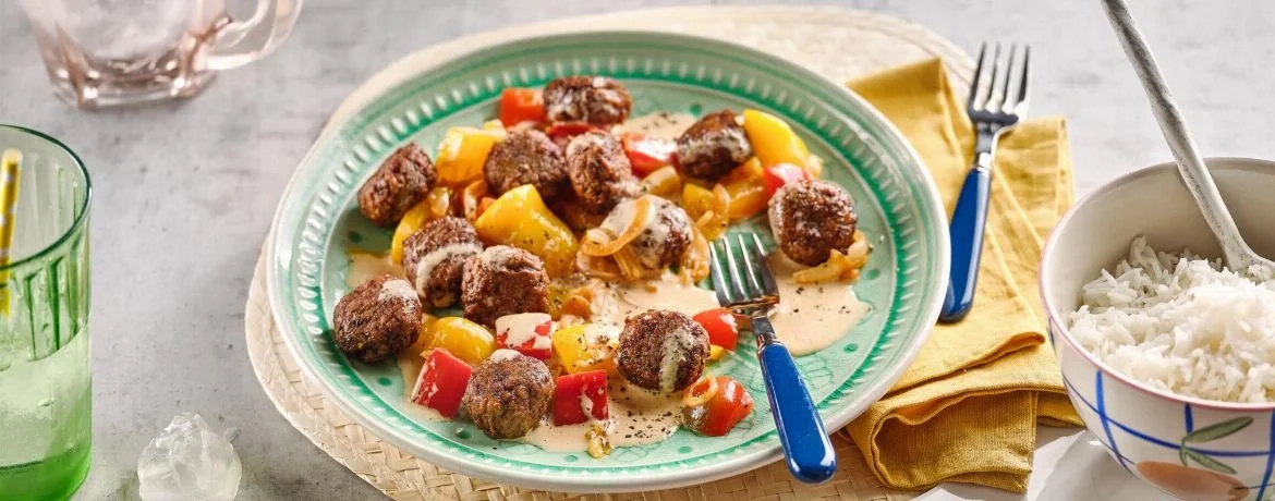 Vegane Frikadellen in cremiger Paprikasauce serviert auf einem Teller