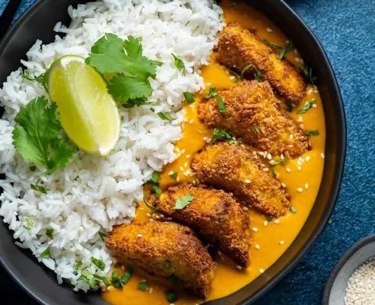Veganes Katsu-Curry mit Gemüse und Reis auf einem Teller angerichtet
