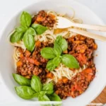 Vegane Linsen Bolognese in einer Schüssel mit frischen Kräutern