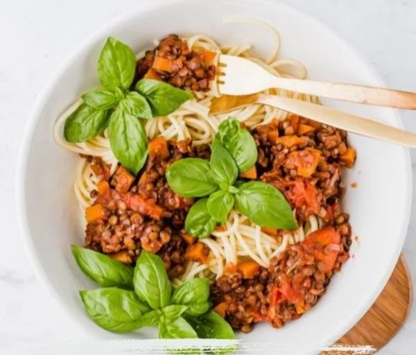 Vegane Linsen Bolognese in einer Schüssel mit frischen Kräutern