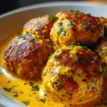 Vegane Linsenknödel in Curry-Sauce auf einem Teller serviert