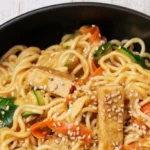 Vegane Mienudeln mit Tofu und buntem Gemüse auf einem Teller