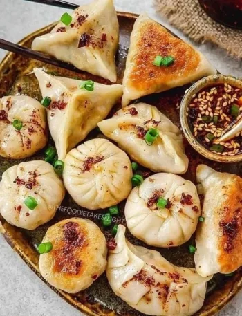 Vegane Potstickers gefüllt mit frischem Gemüse und Gewürzen auf einem Teller.