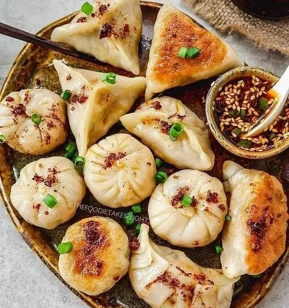 Vegane Potstickers gefüllt mit frischem Gemüse und Gewürzen auf einem Teller.