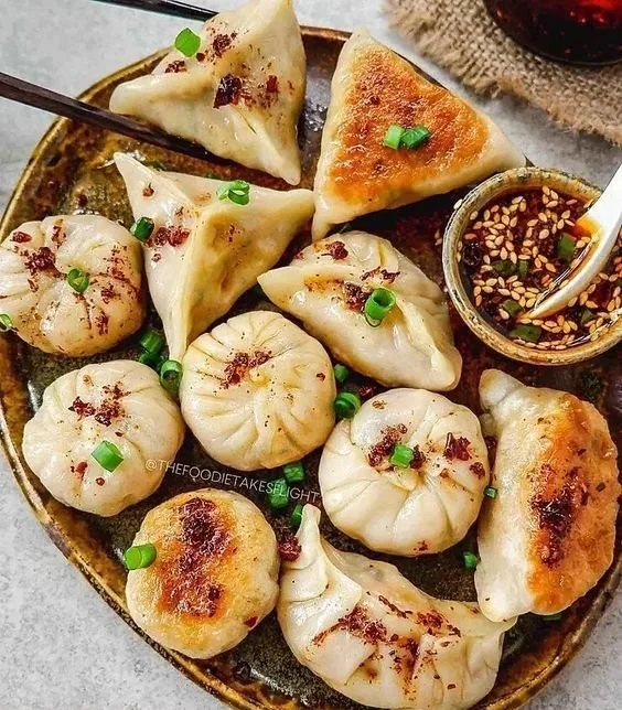 Vegane Potstickers gefüllt mit frischem Gemüse und Gewürzen auf einem Teller.