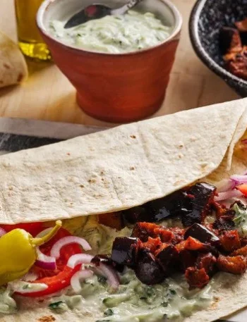 Veganer Auberginen Kebab mit Tzatziki auf einem Teller serviert