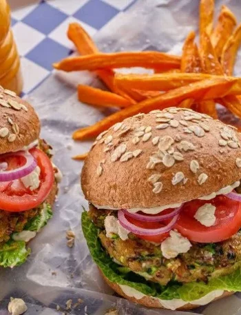 Veganer Zucchini-Hirten-Burger auf einem Teller serviert mit frischen Zutaten.