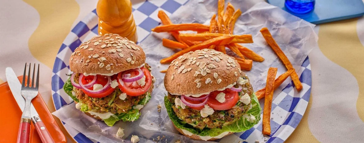 Veganer Zucchini-Hirten-Burger auf einem Teller serviert mit frischen Zutaten.