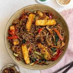 Veganes Japchae mit buntem Gemüse und Glasnudeln, serviert in einer Schüssel.