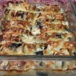 Zucchini Röllchen mit Spinat und Feta auf einem Teller angerichtet.