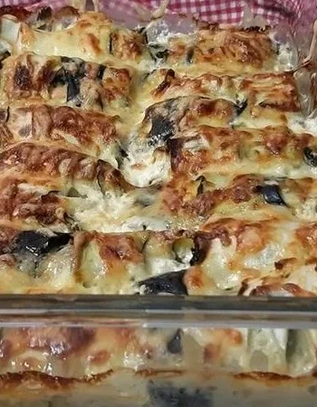 Zucchini Röllchen mit Spinat und Feta auf einem Teller angerichtet.