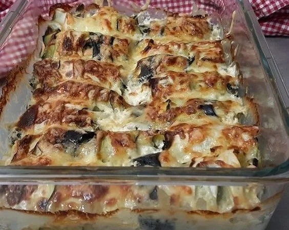 Zucchini Röllchen mit Spinat und Feta auf einem Teller angerichtet.