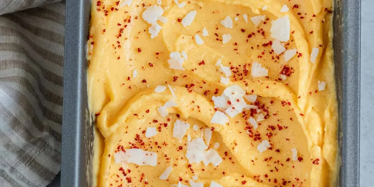Chili-Limetten-Mango-Sorbet in einer Schüssel, dekoriert mit Limettenscheiben und Minze