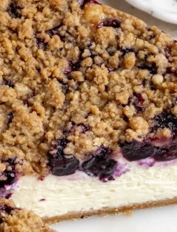 Cremiger Käsekuchen mit Heidelbeeren auf einem weißen Teller