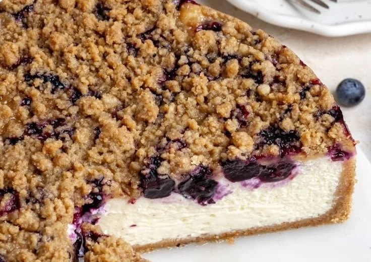 Cremiger Käsekuchen mit Heidelbeeren auf einem weißen Teller