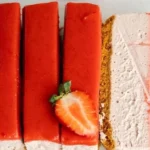 Einfache vegane Erdbeer-Käsekuchen auf einem Teller, dekoriert mit frischen Erdbeeren.