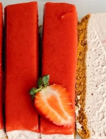 Einfache vegane Erdbeer-Käsekuchen auf einem Teller, dekoriert mit frischen Erdbeeren.