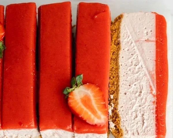 Einfache vegane Erdbeer-Käsekuchen auf einem Teller, dekoriert mit frischen Erdbeeren.
