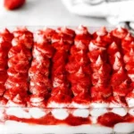 Veganes Erdbeere-Tiramisu auf einem Teller mit Erdbeeren dekoriert