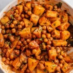 Geröstete Gochujang-Kartoffeln und Kichererbsen auf einem Teller serviert.