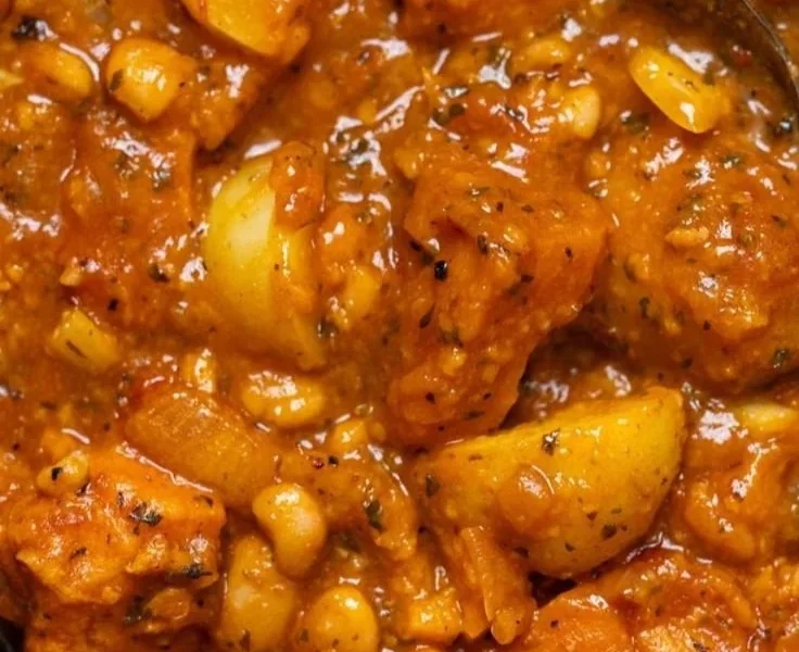 Herzhafter veganer Süßkartoffeleintopf in einer Schüssel mit frischen Kräutern