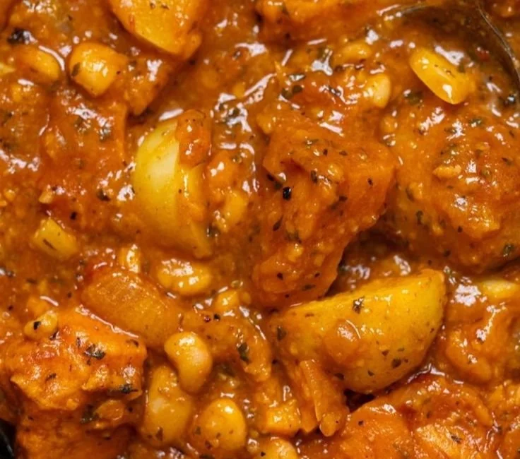 Herzhafter veganer Süßkartoffeleintopf in einer Schüssel mit frischen Kräutern