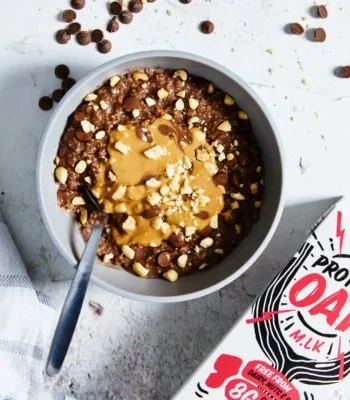 Schüssel mit Karottenkuchen Porridge, dekoriert mit Nüssen und Früchten