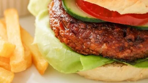 Leckerer Kidneybohnen Burger auf einem Teller mit frischen Zutaten