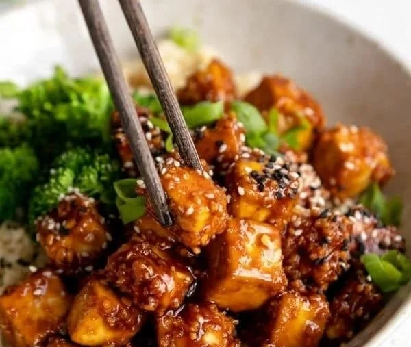 Knoblauch-Sesam-Tofu mit frischen Zutaten auf einem Teller