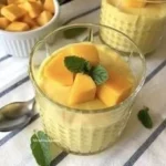 Vegane Mango-Mousse in einer Schüssel, dekoriert mit frischen Mangostreifen.