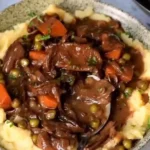 Eine köstliche Schale mit veganem Mushroom Bourguignon, serviert mit frischem Brot.