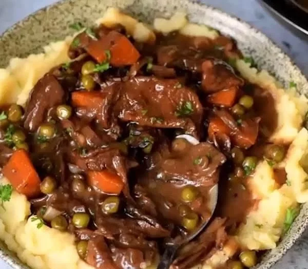 Eine köstliche Schale mit veganem Mushroom Bourguignon, serviert mit frischem Brot.