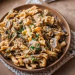 Veganes Pilz-Stroganoff Gericht auf einem Teller mit frischen Kräutern