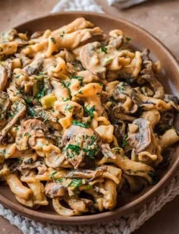 Veganes Pilz-Stroganoff Gericht auf einem Teller mit frischen Kräutern