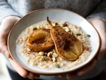 Schüssel mit veganem Porridge mit Früchten und Nüssen garniert