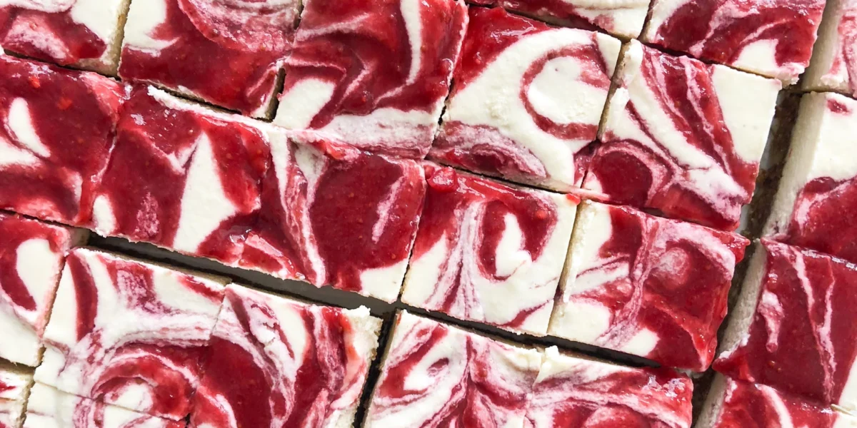 Vegan Strawberry Cheesecake Bites auf einem Teller mit frischen Erdbeeren