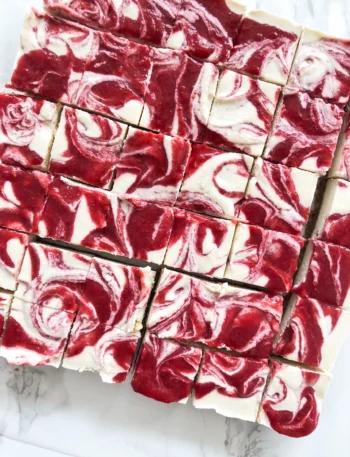 Vegan Strawberry Cheesecake Bites auf einem Teller mit frischen Erdbeeren