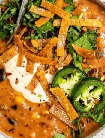 Schüssel mit veganer Tortilla-Suppe mit Gemüse und knusprigen Tortilla-Streifen