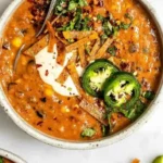 Schüssel mit veganer Tortilla-Suppe, garniert mit Tortilla-Chips und frischem Koriander